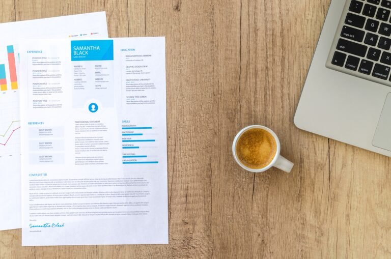 Resume and laptop on a desk while writing a CV