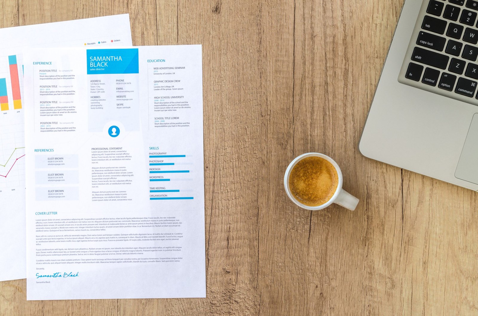 Resume and laptop on a desk while writing a CV