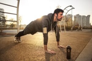 Man doing push-ups outdoors during sunrise workout