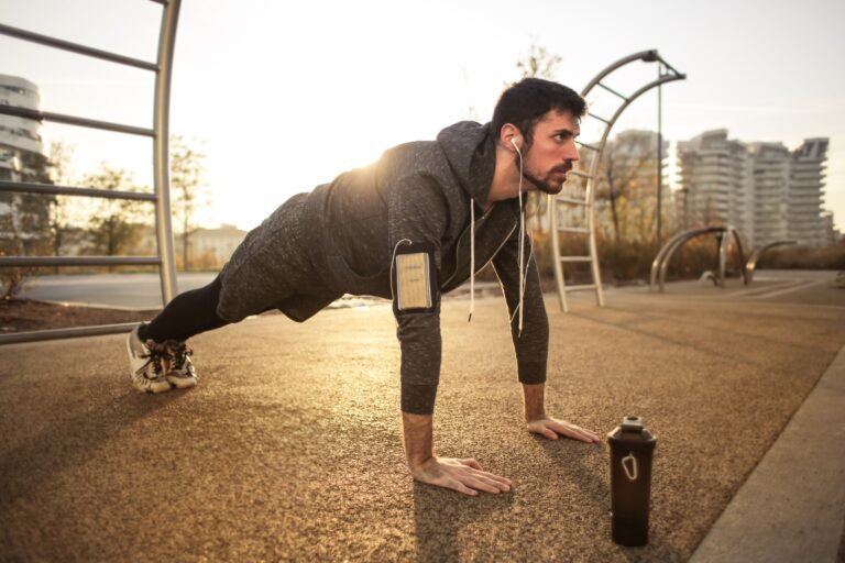 Man doing push-ups outdoors during sunrise workout