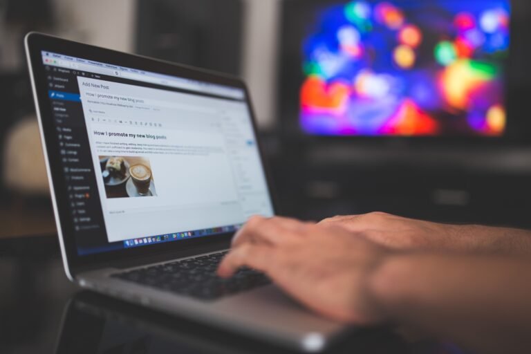 Hands typing a blog post on a laptop